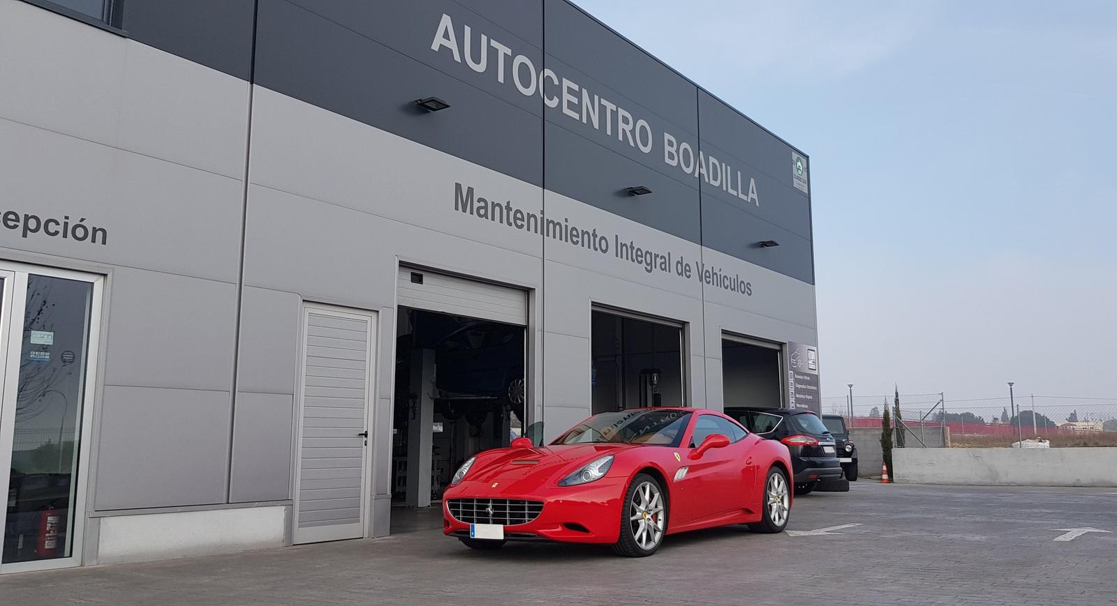 Ferrari California rojo de un cliente aparcado ante la fachada de Autocentro Boadilla